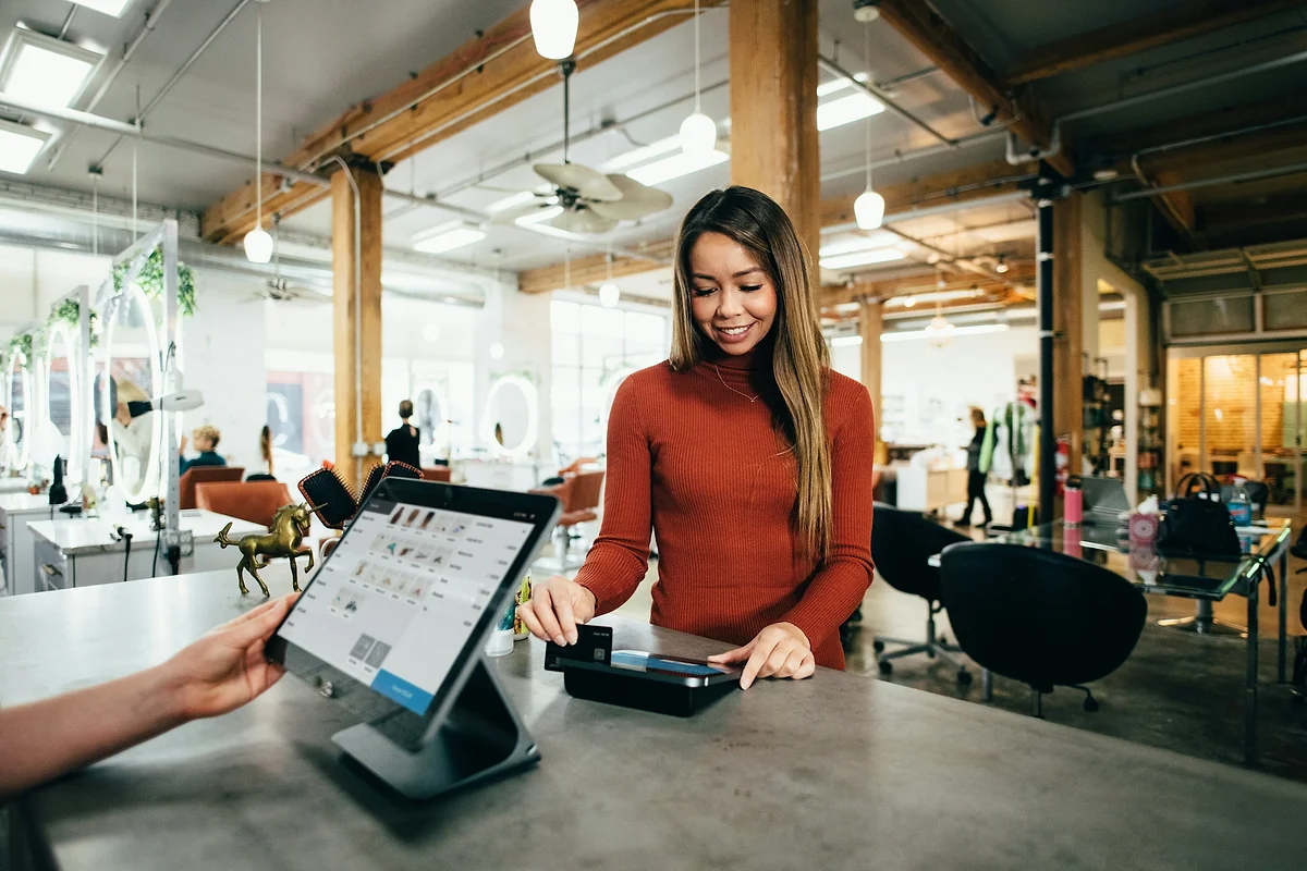 Commerçante qui encaisse un paiement par carte sur une caisse tactile